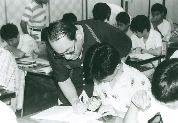 写真：中萬学院名物夏期合宿特訓で生徒を指導する中萬学院長（現名誉会長）